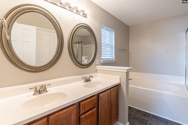 bathroom featuring vanity, tiled bath, and tile patterned flooring