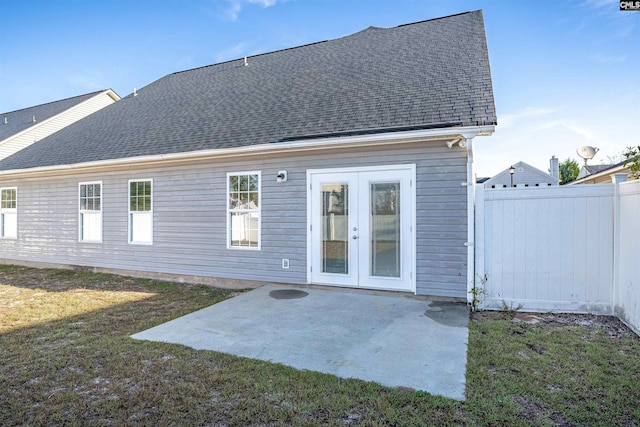 rear view of property with a lawn, a patio area, and french doors