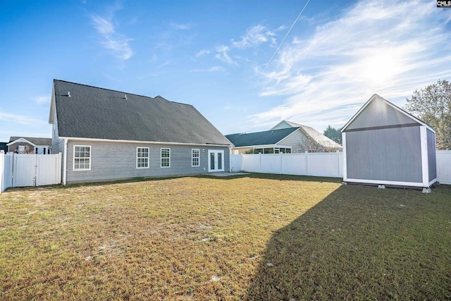 rear view of property with a yard and a shed