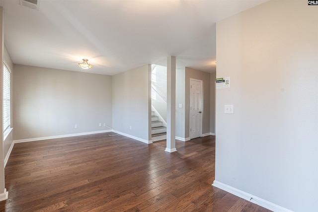 spare room with a wealth of natural light and dark wood-type flooring