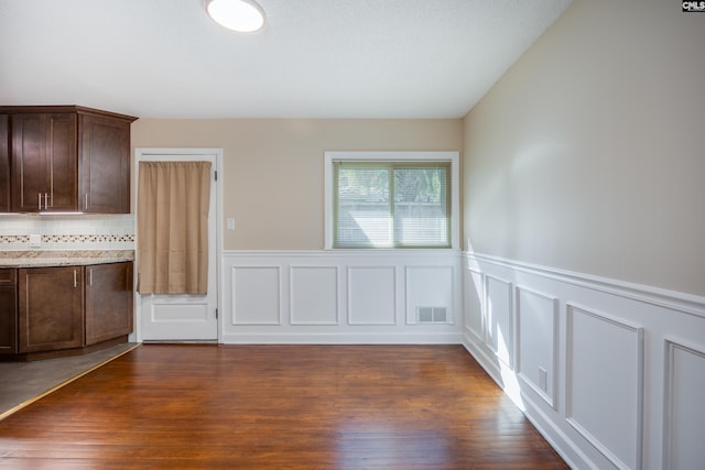 unfurnished dining area featuring dark hardwood / wood-style flooring