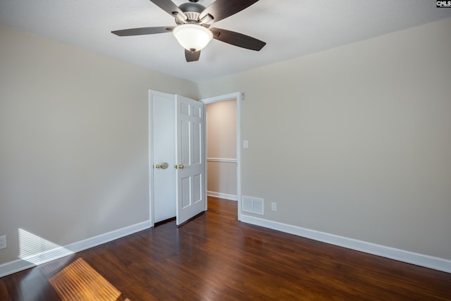 empty room featuring ceiling fan and dark wood-type flooring