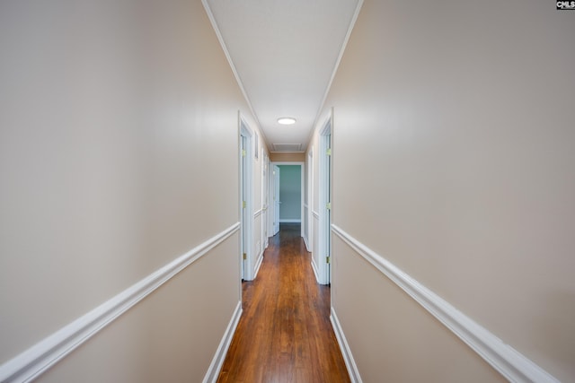 hall featuring ornamental molding and dark wood-type flooring