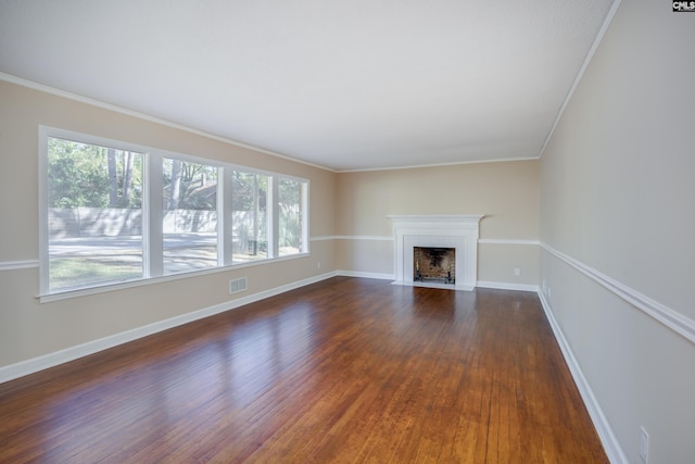 unfurnished living room with ornamental molding, dark wood-type flooring, and plenty of natural light