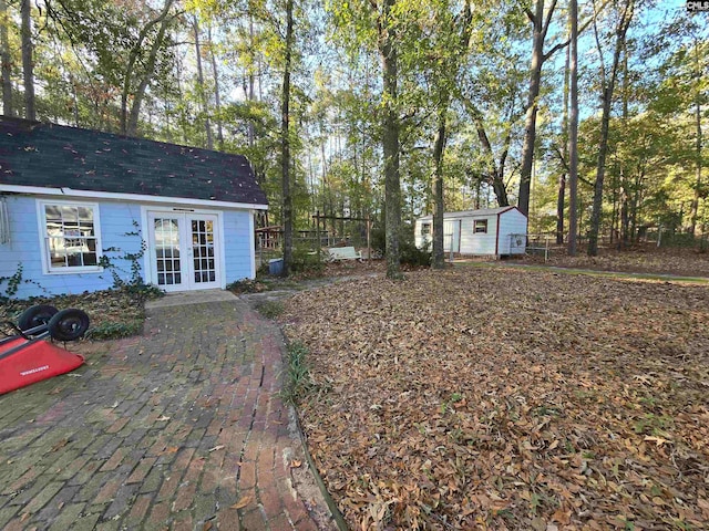 view of yard with french doors and an outdoor structure