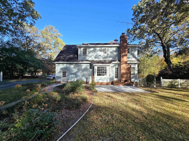 rear view of property with a yard and a patio