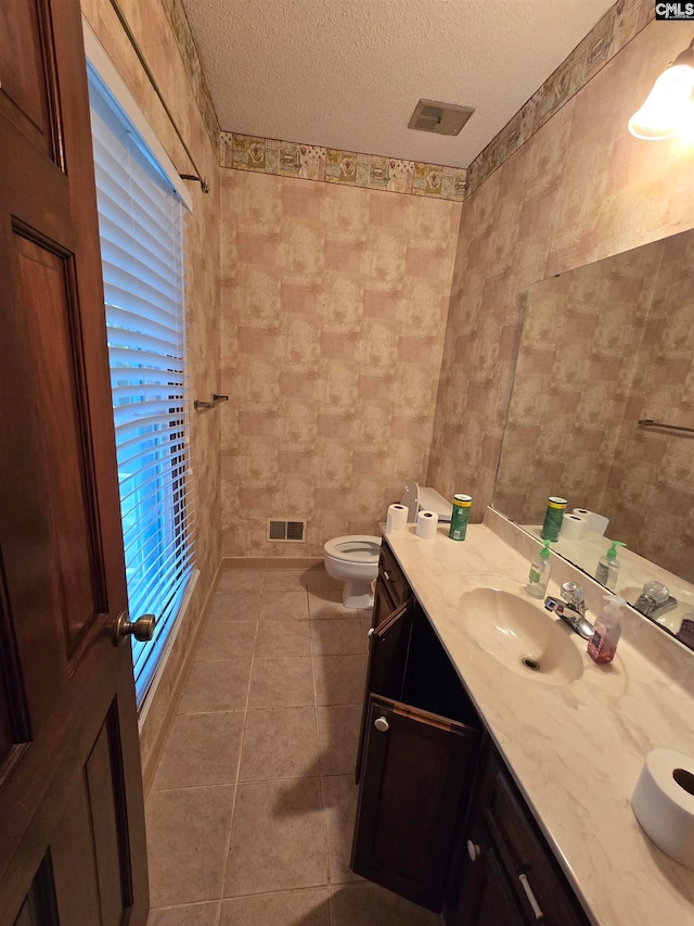 bathroom with a textured ceiling, tile patterned flooring, tile walls, and vanity