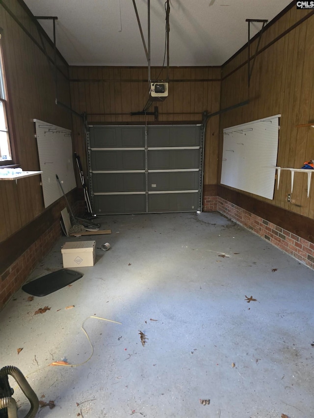 garage with wood walls and a garage door opener