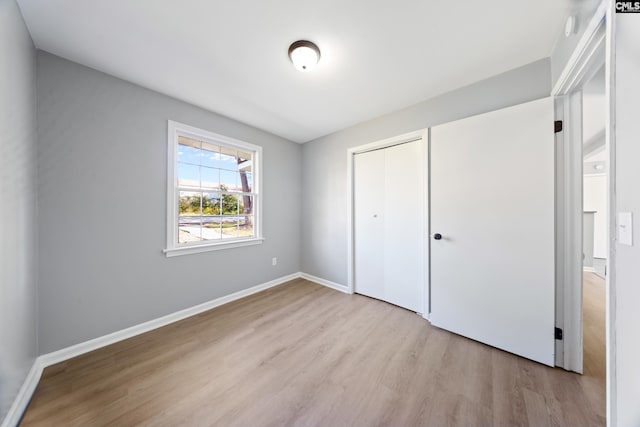 unfurnished bedroom featuring a closet and light hardwood / wood-style flooring