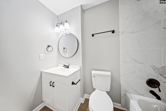 full bathroom featuring tiled shower / bath, vanity, and toilet