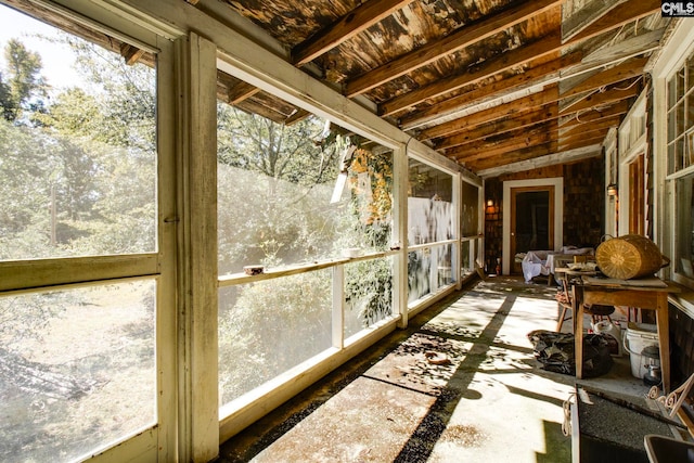 sunroom / solarium featuring a healthy amount of sunlight and lofted ceiling