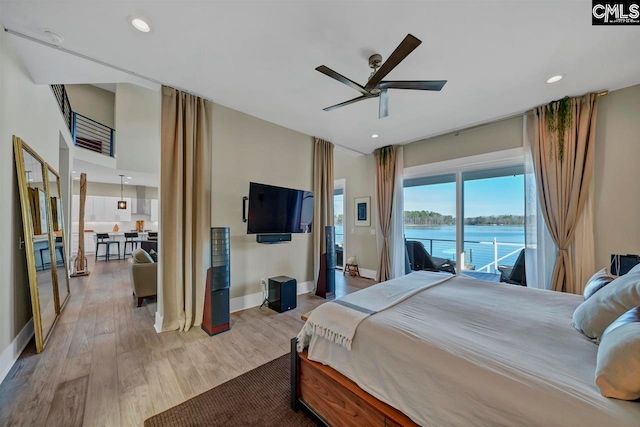 bedroom featuring access to exterior, ceiling fan, and light wood-type flooring