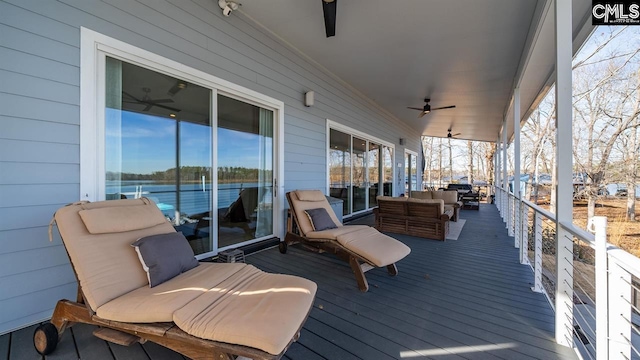 wooden deck with an outdoor living space and ceiling fan