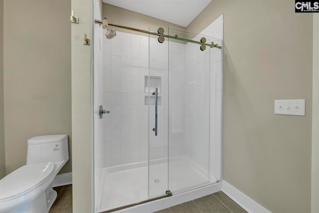 bathroom with tile patterned flooring, toilet, and an enclosed shower