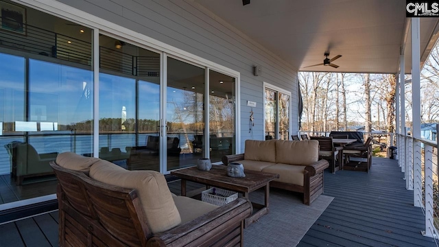 wooden deck with an outdoor living space and ceiling fan