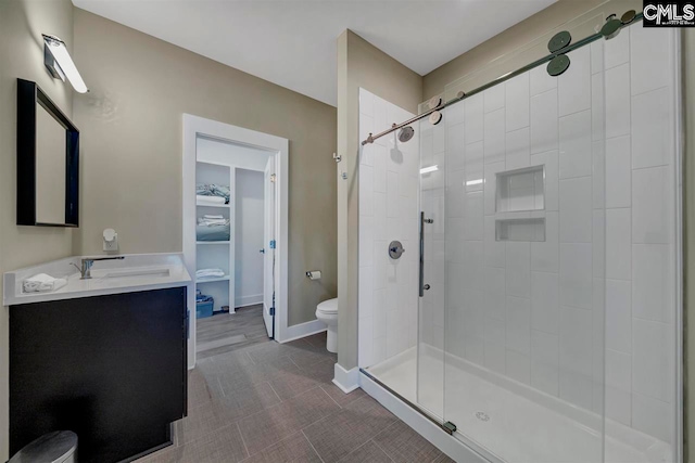 bathroom with vanity, toilet, and a shower with shower door