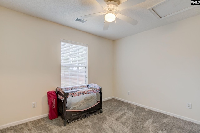 bedroom with ceiling fan, carpet floors, and a textured ceiling