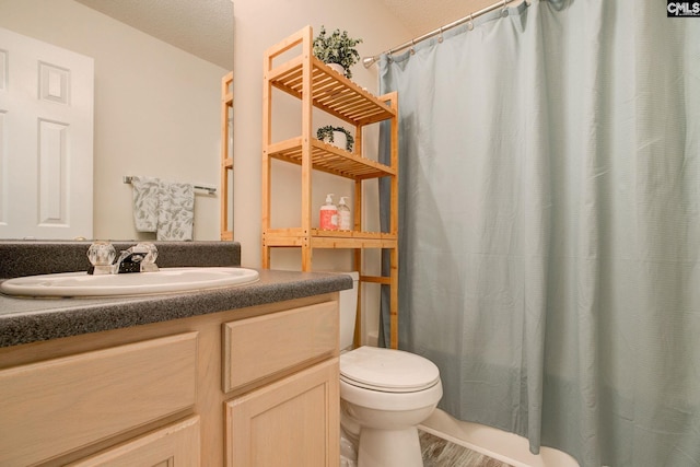 bathroom featuring hardwood / wood-style floors, vanity, toilet, and a textured ceiling