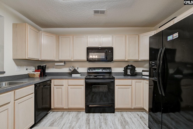 kitchen with a textured ceiling, sink, black appliances, light brown cabinets, and light hardwood / wood-style flooring