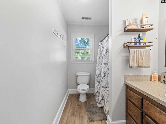 bathroom with toilet, hardwood / wood-style floors, vanity, and ornamental molding