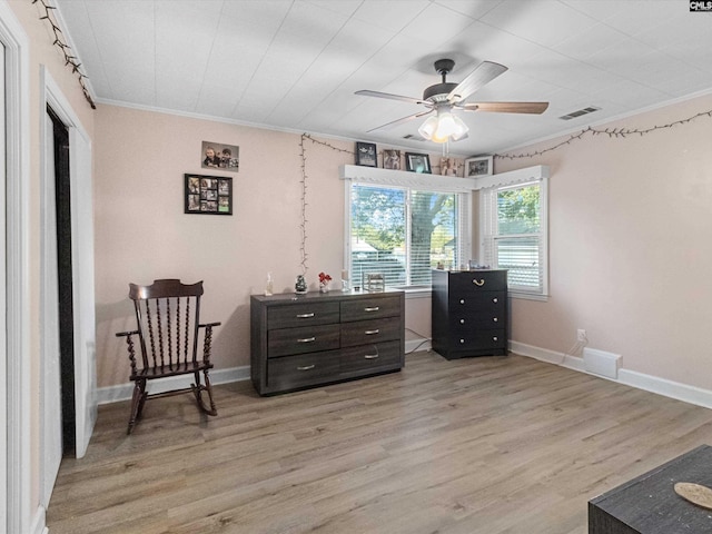 sitting room with crown molding, light hardwood / wood-style flooring, and ceiling fan