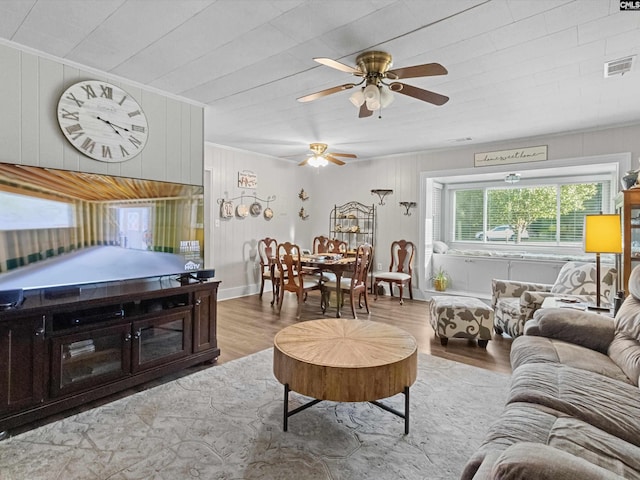 living room with ceiling fan, wooden walls, and hardwood / wood-style flooring