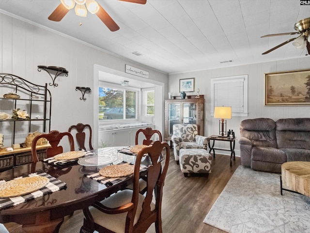 dining space featuring ceiling fan, crown molding, and dark wood-type flooring