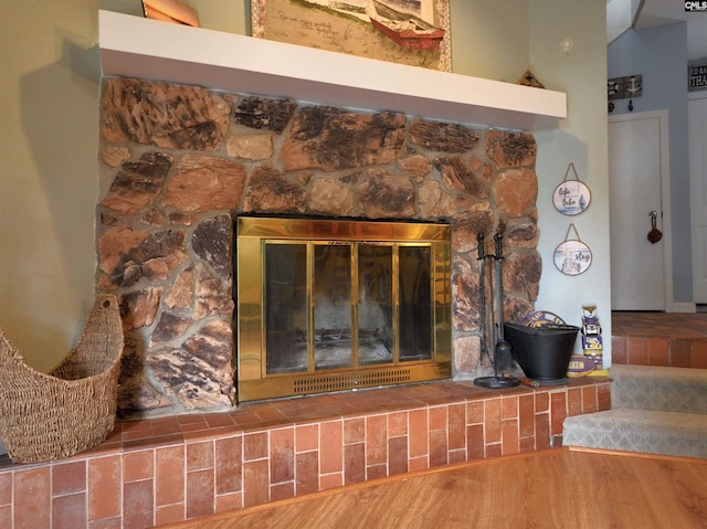 interior details featuring wood-type flooring and a stone fireplace