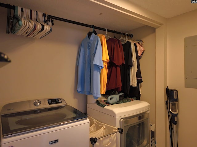 clothes washing area with electric panel and washer and dryer