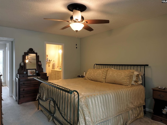 bedroom featuring ceiling fan, carpet floors, ensuite bathroom, and a textured ceiling