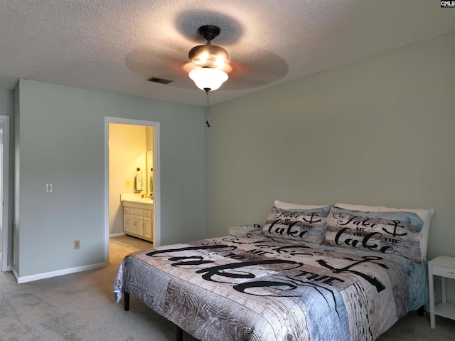 bedroom featuring connected bathroom, ceiling fan, light carpet, and a textured ceiling