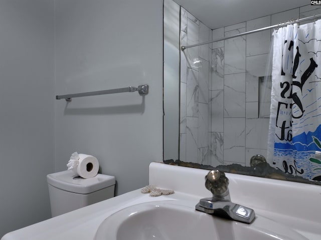 bathroom featuring a shower with curtain, toilet, and sink