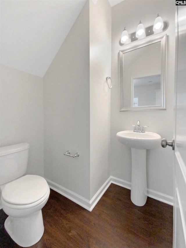 bathroom featuring sink, hardwood / wood-style floors, lofted ceiling, and toilet