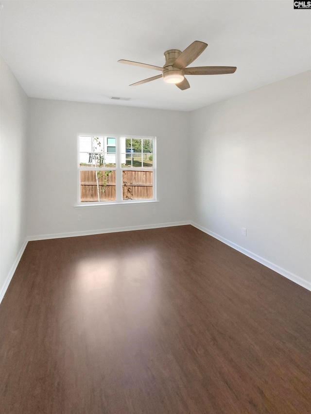 empty room featuring ceiling fan and dark wood-type flooring