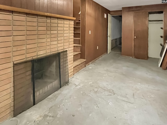 4650 Crystal Dr, Columbia, SC 29206 - unfurnished living room featuring unfinished concrete floors, a brick fireplace, and wood walls