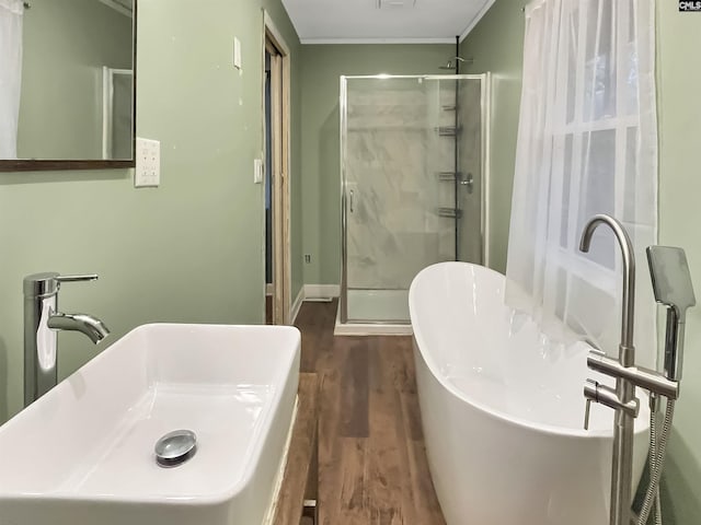 4650 Crystal Dr, Columbia, SC 29206 - full bathroom with wood finished floors, a shower stall, a sink, a freestanding bath, and baseboards