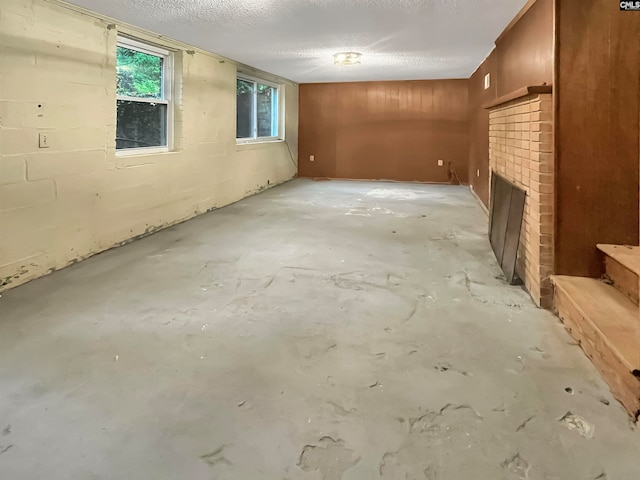 basement with a textured ceiling and a brick fireplace