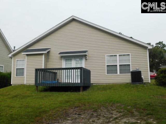 back of house featuring central air condition unit, a deck, and a lawn