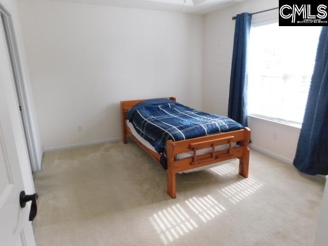 bedroom with light carpet and multiple windows