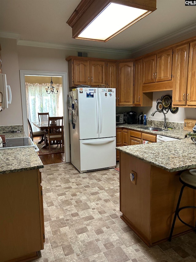 kitchen featuring kitchen peninsula, white appliances, crown molding, an inviting chandelier, and hanging light fixtures