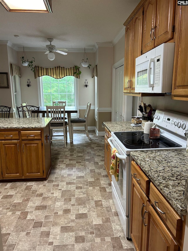 kitchen featuring light stone countertops, ornamental molding, a textured ceiling, white appliances, and ceiling fan