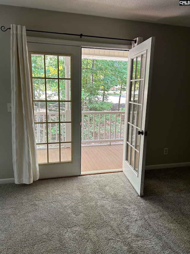 doorway to outside with carpet flooring, french doors, and a textured ceiling