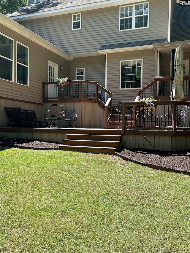 rear view of house with a lawn and a deck