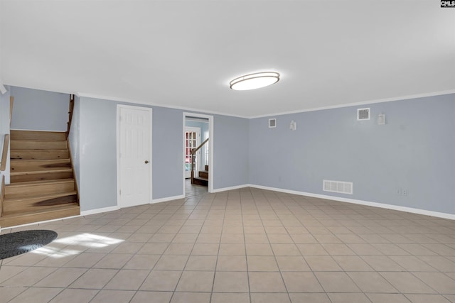 spare room featuring light tile patterned flooring and ornamental molding