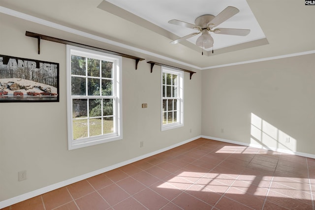 tiled empty room featuring ceiling fan, a raised ceiling, and crown molding