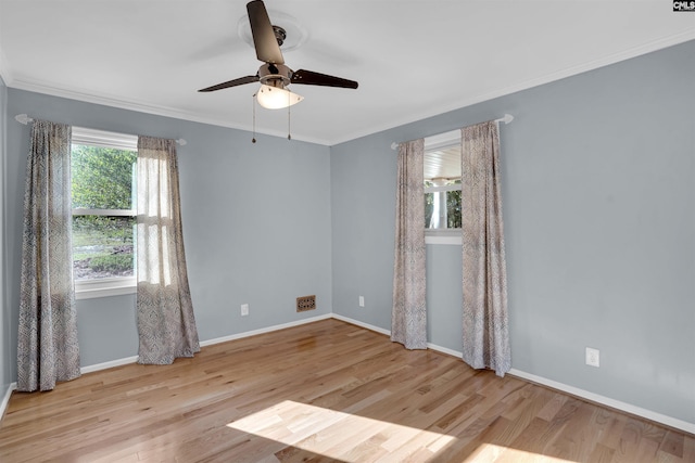 spare room featuring light wood-type flooring, ceiling fan, and crown molding