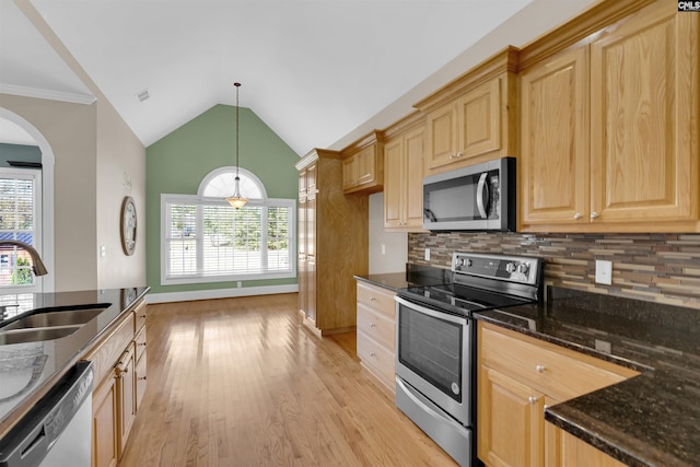 kitchen with sink, stainless steel appliances, pendant lighting, decorative backsplash, and light wood-type flooring