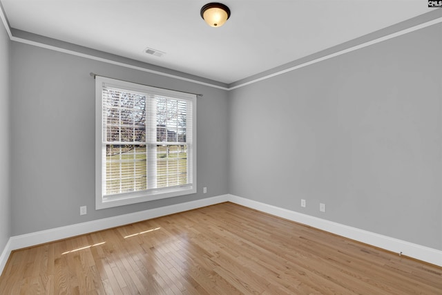 unfurnished room with crown molding and light wood-type flooring