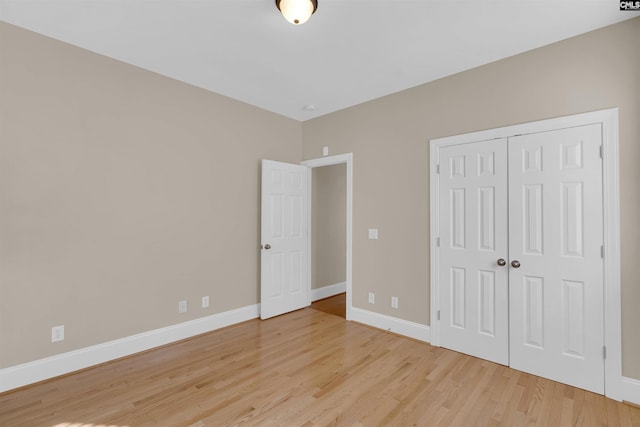 unfurnished bedroom with light hardwood / wood-style floors and a closet