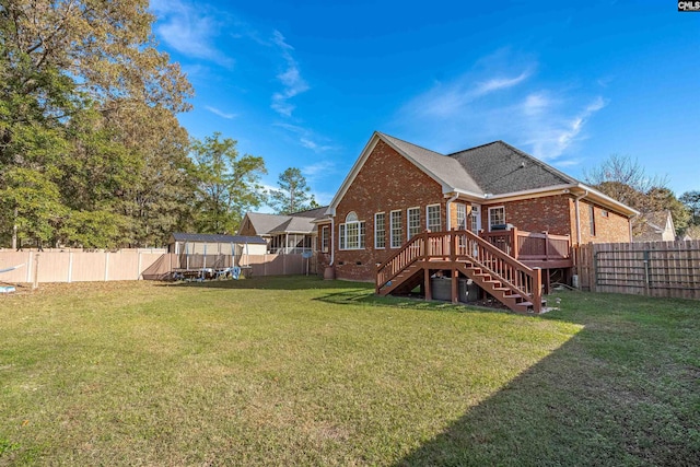 rear view of property featuring a lawn and a wooden deck